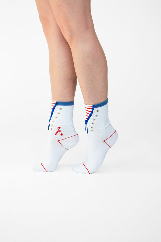 Atypical Attire socks are unique socks and luxury socks. These Striped Zip Up socks are unisex white cotton socks with a blue zip and a red striped pattern for a fun quirky style. They contain silver eyelets and can be worn zipped up or zipped down. They have a red line over the toes and outlining the heel of the sock.