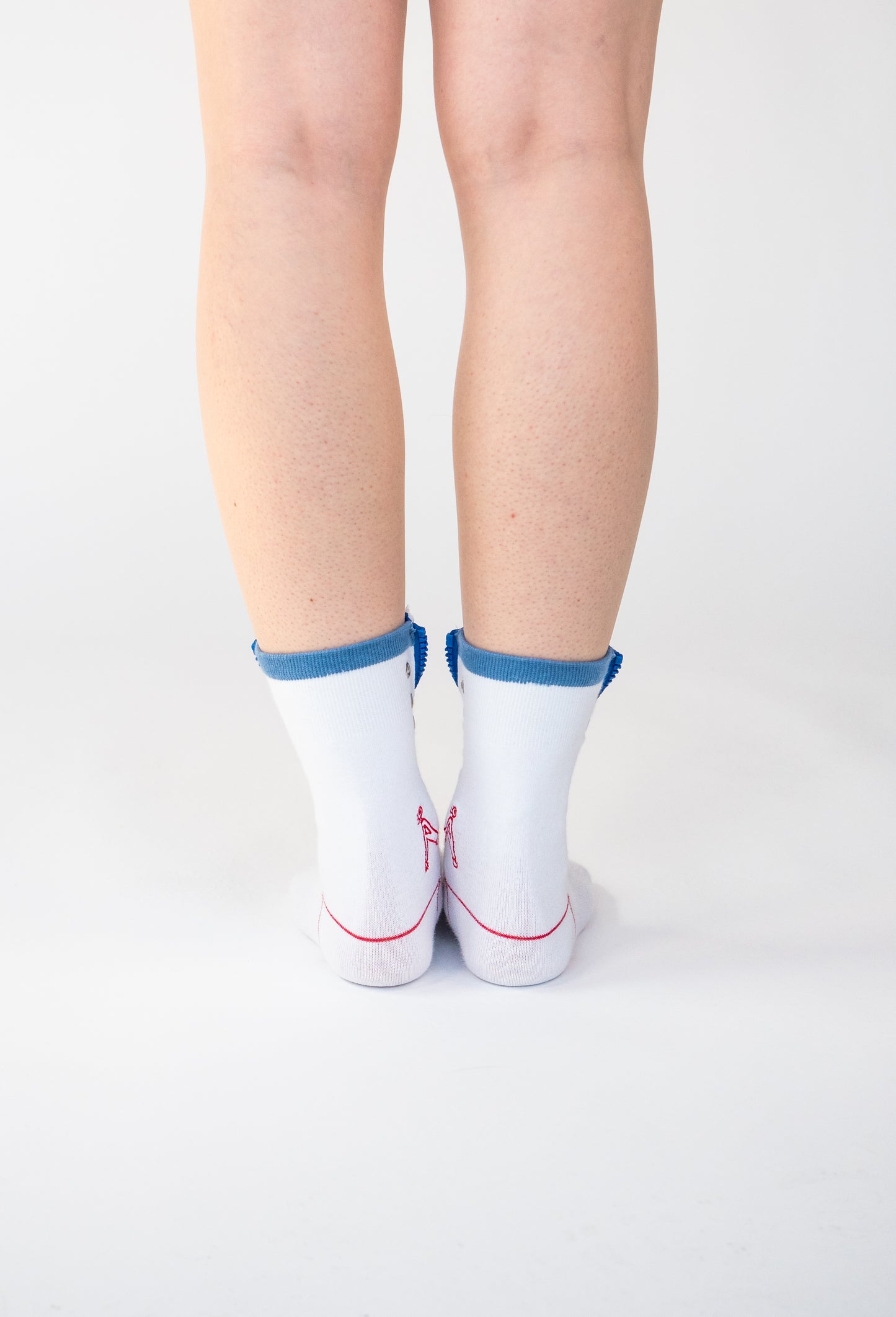 Atypical Attire socks are unique socks and luxury socks. These Striped Zip Up socks are unisex white cotton socks with a blue zip and a red striped pattern for a fun quirky style. They contain silver eyelets and can be worn zipped up or zipped down. They have a red line over the toes and outlining the heel of the sock.