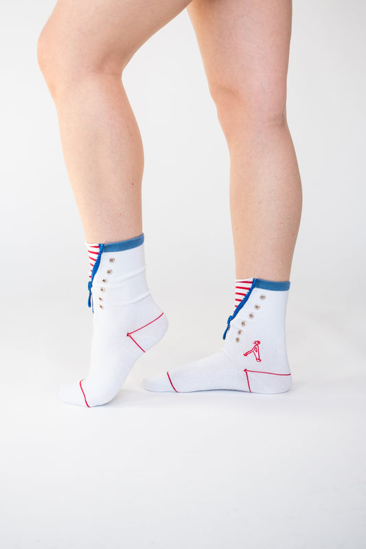 Atypical Attire socks are unique socks and luxury socks. These Striped Zip Up socks are unisex white cotton socks with a blue zip and a red striped pattern for a fun quirky style. They contain silver eyelets and can be worn zipped up or zipped down. They have a red line over the toes and outlining the heel of the sock.