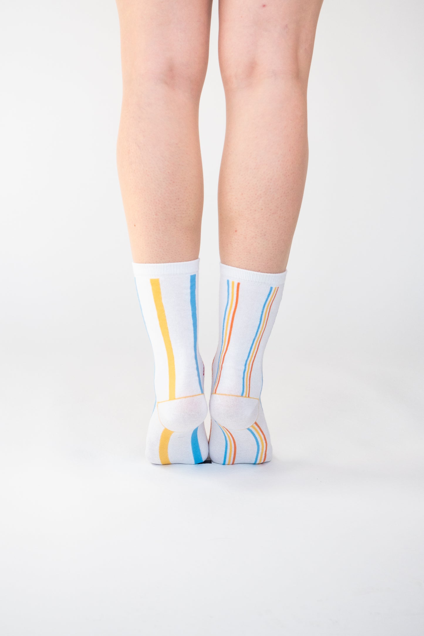 Atypical Attire socks are unique socks and luxury socks. These Multi-Striped socks are unisex white cotton socks which contain blue, yellow and orange stripes. One sock has thick stripes, the other sock has thin stripes to create a mismatching pair.