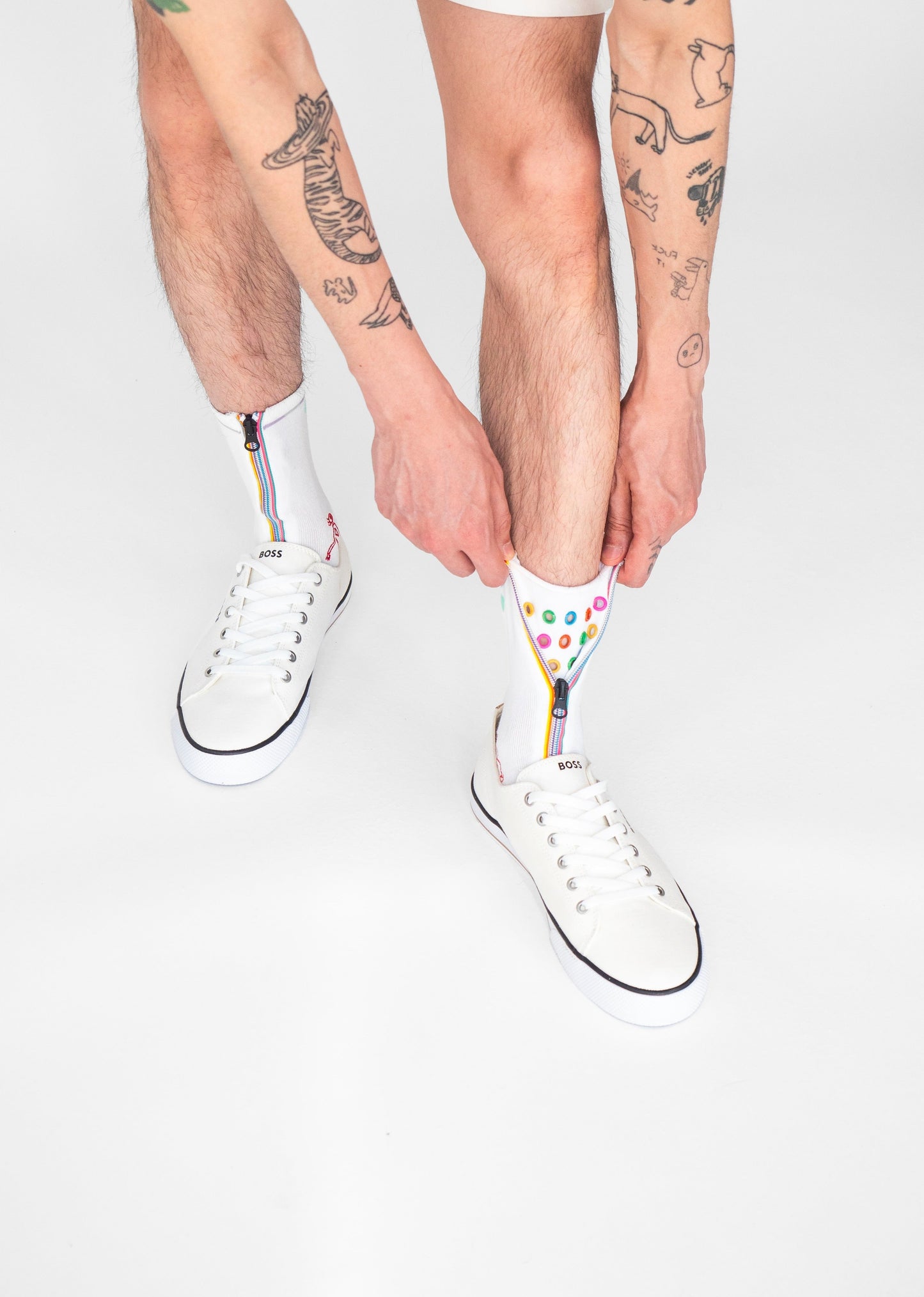 Colour Hoop Zipper socks. Atypical Attire socks are unique socks and luxury socks. These white cotton socks contain multicoloured eyelets and colourful striped zips with a zipper for a fun summer style and are worn with converses and jeans. They can be worn zipped up or zipped down. Colours of eyelets include pink, orange, yellow, blue, red, green and purple.