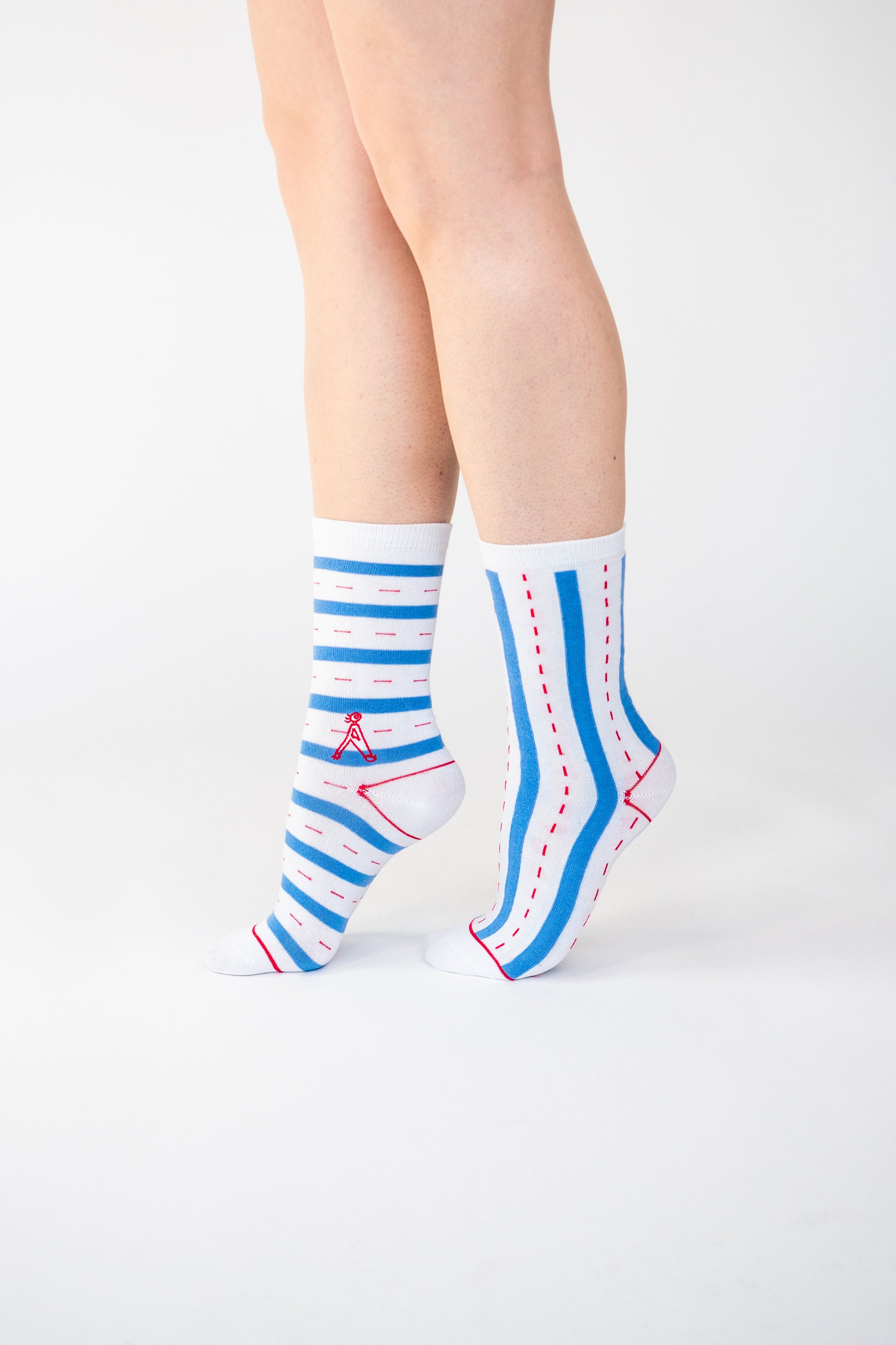 Atypical Attire socks are unique socks and luxury socks. These Verti-zontical socks are unisex white cotton socks which contain blue stripes with a red dotted line in between. One sock has horizontal stripes, the other sock has vertical stripes to create a mismatching pair.