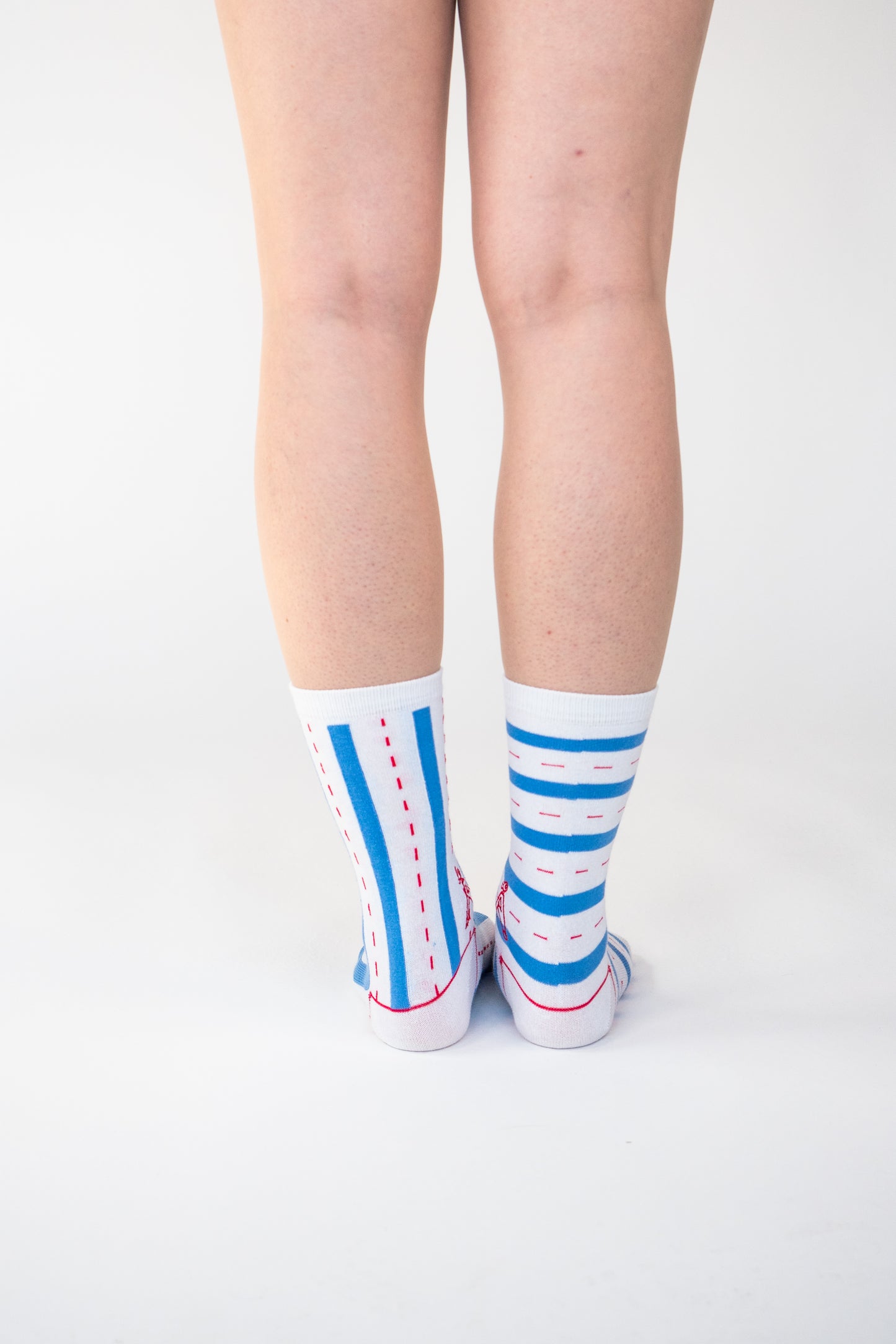 Atypical Attire socks are unique socks and luxury socks. These Verti-zontical socks are unisex white cotton socks which contain blue stripes with a red dotted line in between. One sock has horizontal stripes, the other sock has vertical stripes to create a mismatching pair.