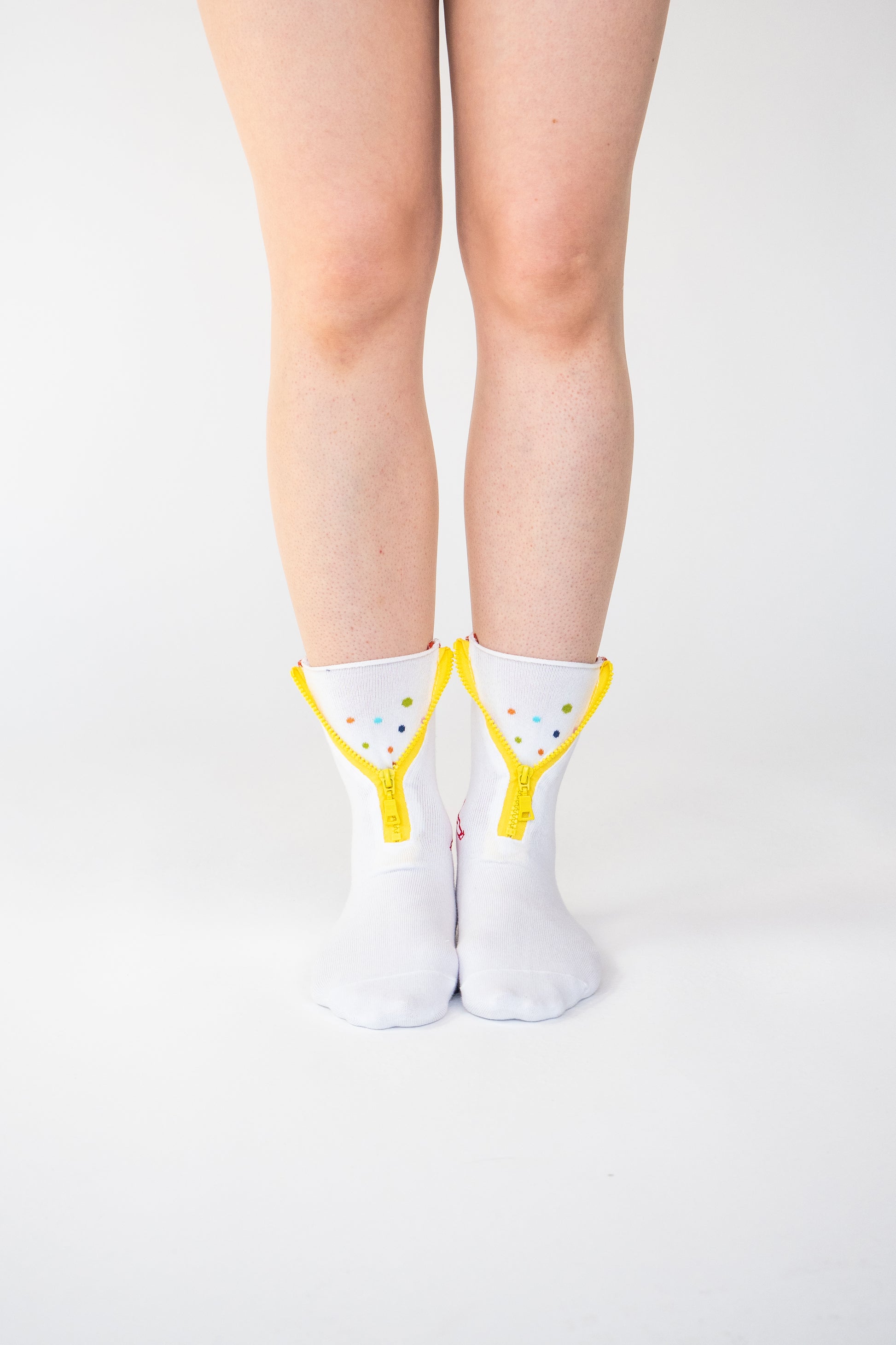 Atypical Attire socks are unique socks and luxury socks. These Dotty Spotty socks are unisex white cotton socks which contain a yellow zip and multicoloured spots. Polkadots appear in orange, blue, purple and yellow. 