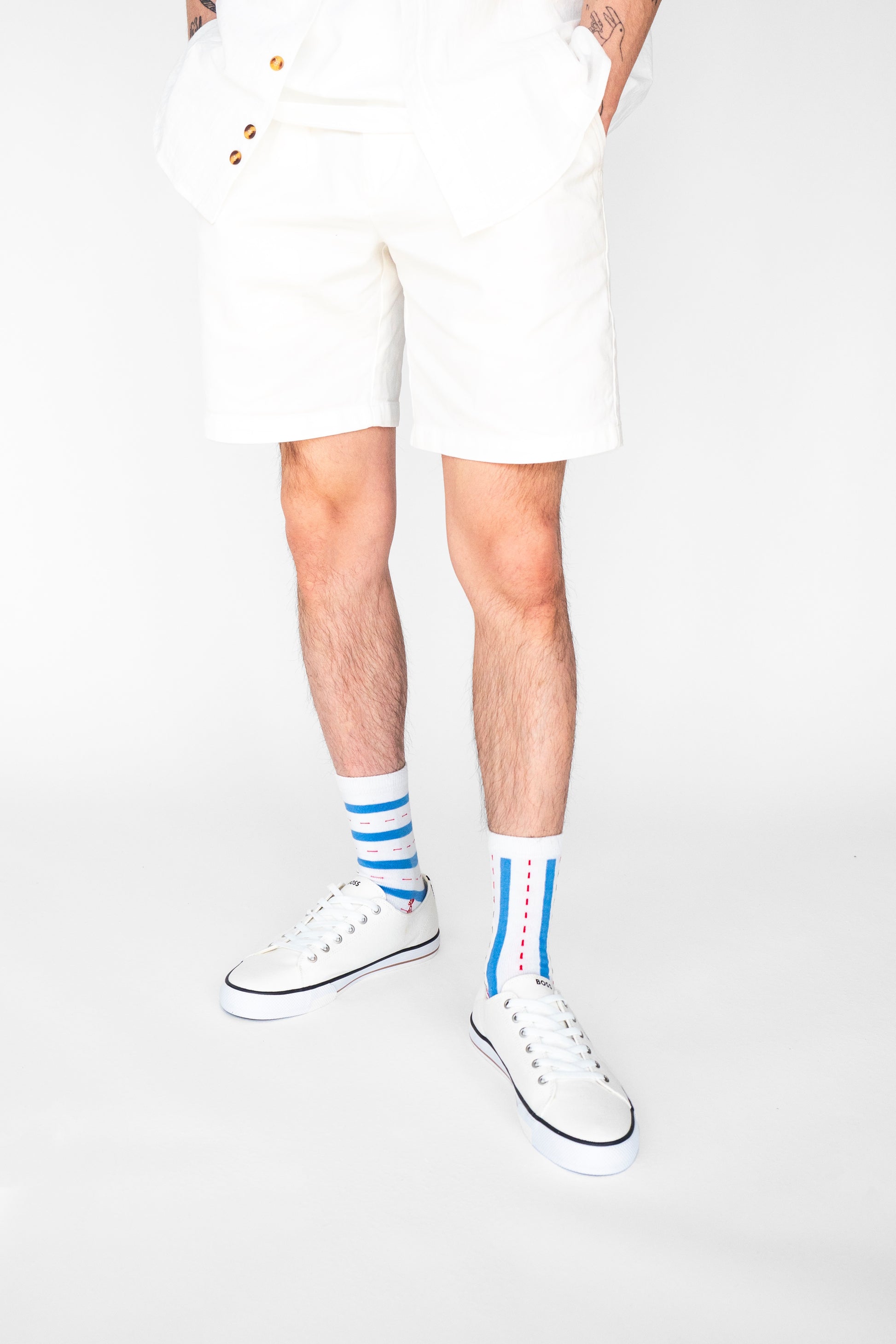 Atypical Attire socks are unique socks and luxury socks. These Verti-zontical socks are unisex white cotton socks which contain blue stripes with a red dotted line in between. One sock has horizontal stripes, the other sock has vertical stripes to create a mismatching pair.