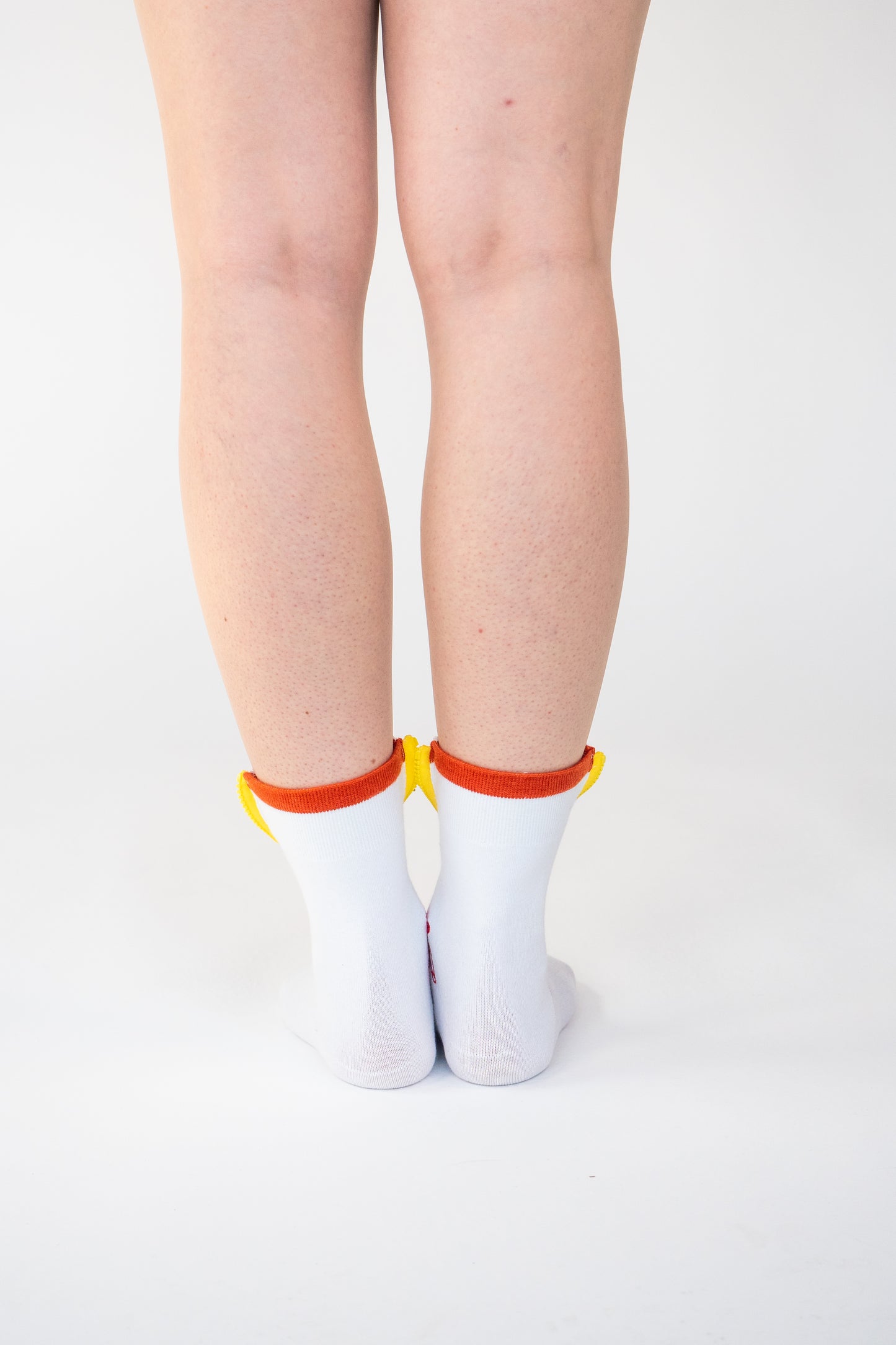 Atypical Attire socks are unique socks and luxury socks. These Dotty Spotty socks are unisex white cotton socks which contain a yellow zip and multicoloured spots. Polkadots appear in orange, blue, purple and yellow. 