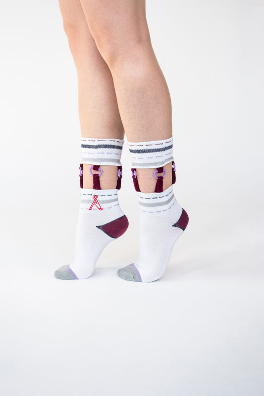 Atypical Attire socks are unique socks and luxury socks. These D-Ring Suspender socks are unisex white cotton socks which contain grey and purple stripes and colourful strips with purple D rings.