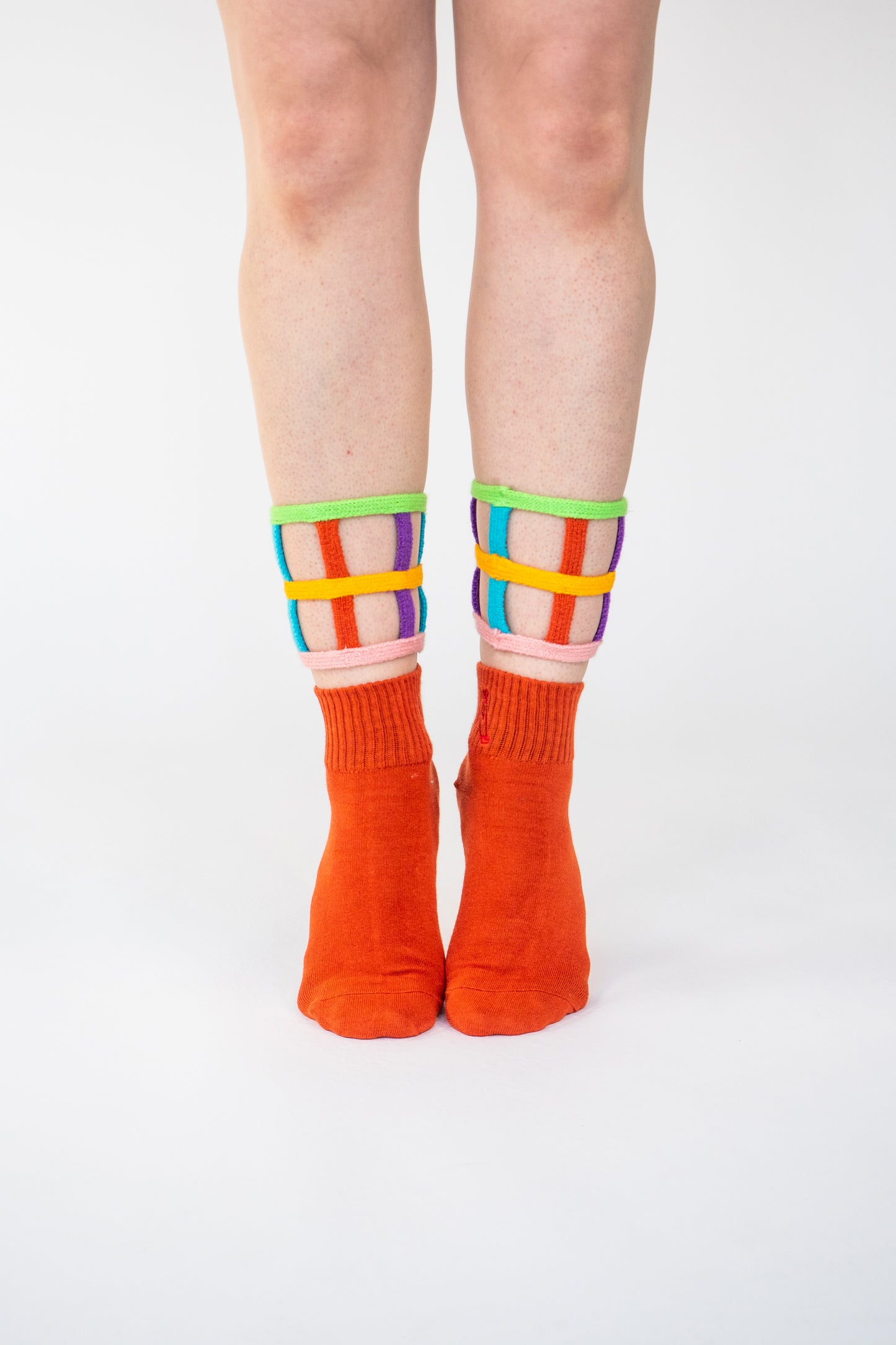 Atypical Attire socks are unique socks and luxury socks. These bright multicoloured colour cuff socks are made from cotton. They have handmade components. These are two-part orange socks with purple, pink, green, blue and yellow strips.