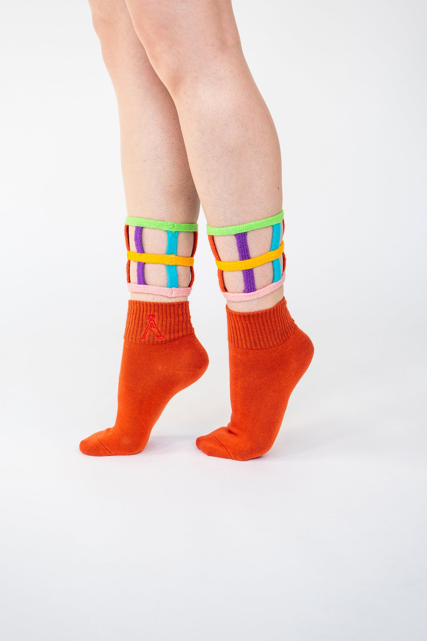 Atypical Attire socks are unique socks and luxury socks. These bright multicoloured colour cuff socks are made from cotton. They have handmade components. These are two-part orange socks with purple, pink, green, blue and yellow strips.