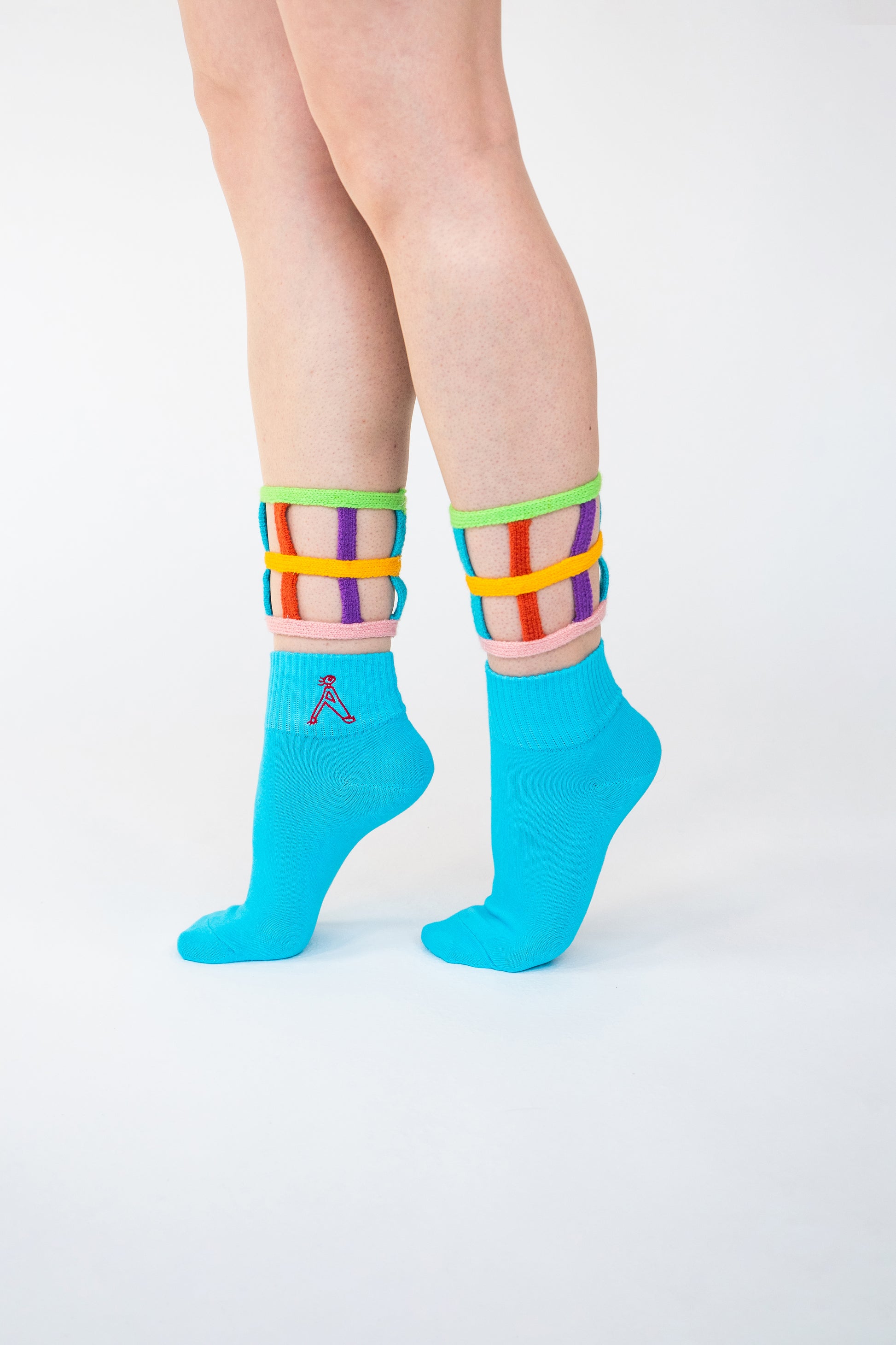 Atypical Attire socks are unique socks and luxury socks. These bright multicoloured colour cuff socks are made from cotton. They have handmade components. These are two-part light and bright blue socks with purple, pink, green, blue and yellow strips.