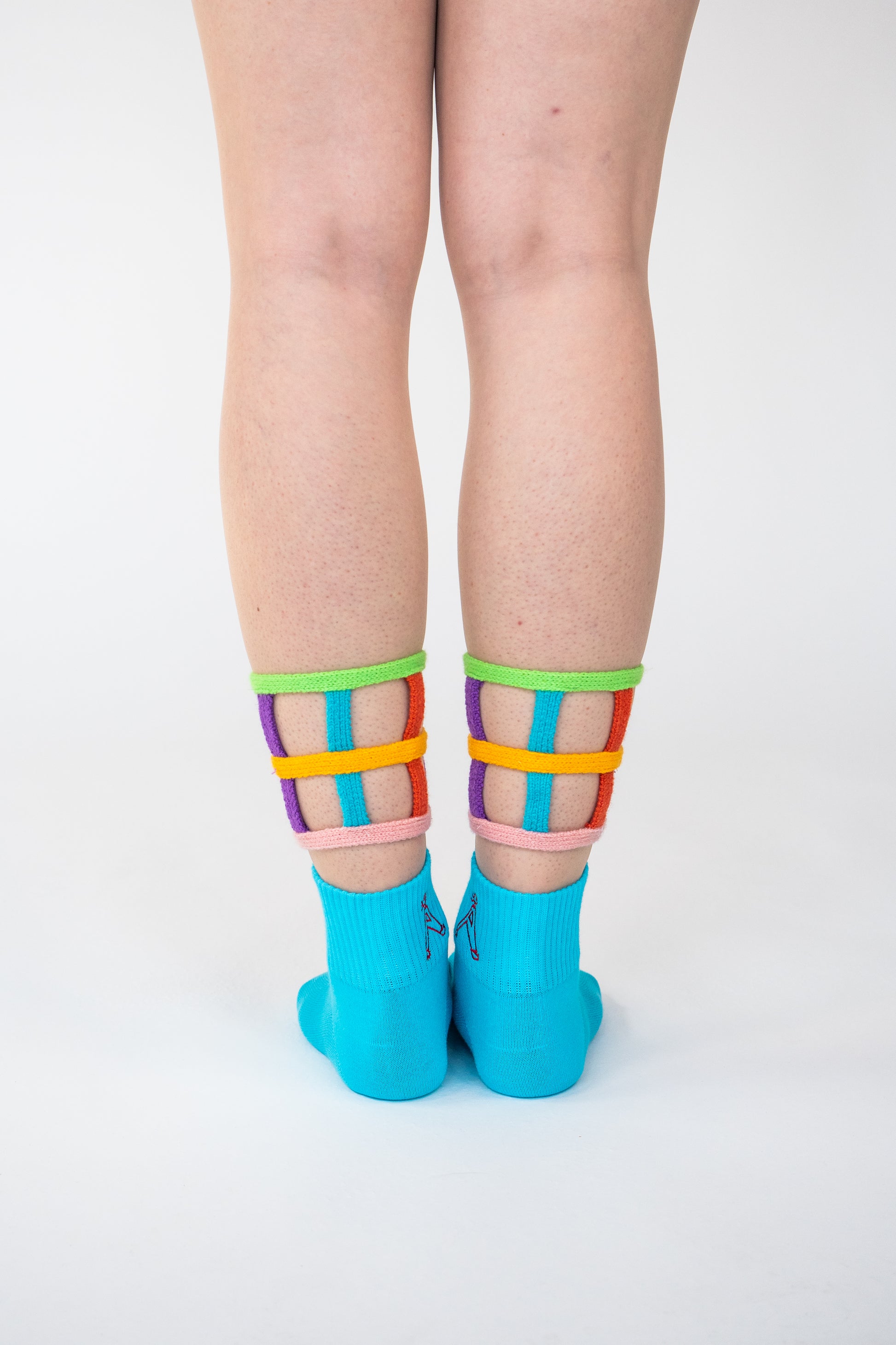 Atypical Attire socks are unique socks and luxury socks. These bright multicoloured colour cuff socks are made from cotton. They have handmade components. These are two-part light and bright blue socks with purple, pink, green, blue and yellow strips.