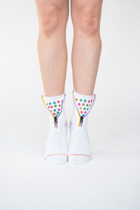 Colour Hoop Zipper socks. Atypical Attire socks are unique socks and luxury socks. These white cotton socks contain multicoloured eyelets and colourful striped zips with a zipper for a fun summer style and are worn with converses and jeans. They can be worn zipped up or zipped down. Colours of eyelets include pink, orange, yellow, blue, red, green and purple.