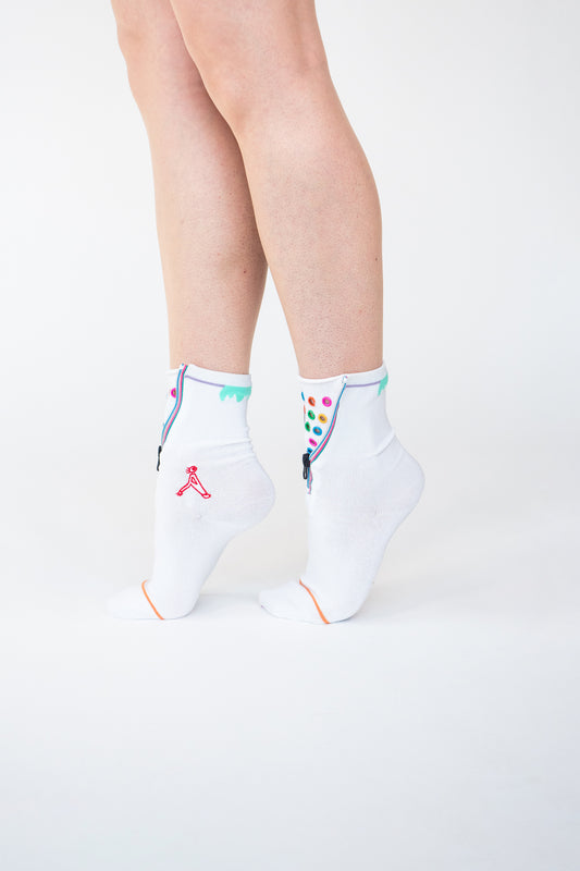 Colour Hoop Zipper socks. Atypical Attire socks are unique socks and luxury socks. These white cotton socks contain multicoloured eyelets and colourful striped zips with a zipper for a fun summer style and are worn with converses and jeans. They can be worn zipped up or zipped down. Colours of eyelets include pink, orange, yellow, blue, red, green and purple.